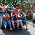 group on truckbed sings and claps as part of Sundale Memorial Day Parade